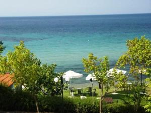 plaża z leżakami i parasolami oraz ocean w obiekcie Para Thin Alos Inn w mieście Neos Marmaras