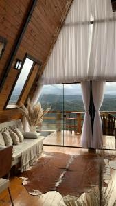 a living room with a bed and a large window at Chales alto do morro 1, conforto e vista privilegiada in Rancho Queimado