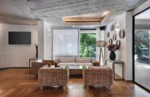 a living room with a couch and wicker chairs at Jacob Nea in Shave Ẕiyyon