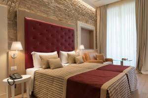 a bedroom with a large bed and a brick wall at Navona Luxury Guesthouse in Rome