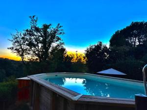 a swimming pool with a sunset in the background at Ciliegia di Lari - Attico in Lari