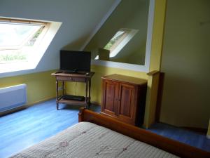 um quarto com uma cama e uma televisão numa mesa em Briois Cristelle em Penmarcʼh