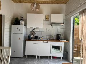 a kitchen with white cabinets and a white refrigerator at La BEL KREOL in Le Gosier