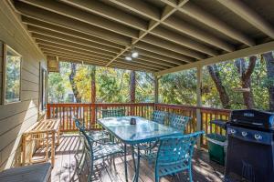 een terras met een tafel en stoelen op een dek bij Cozy Cabin by Bass Lake, with Boat Slip in Bass Lake