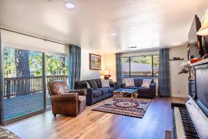 een woonkamer met een bank en een piano bij Cozy Cabin by Bass Lake, with Boat Slip in Bass Lake