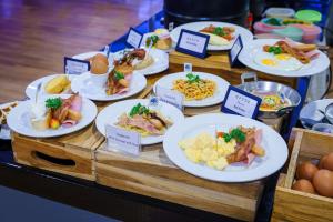 a buffet with plates of food on a table at Icon Park Hotel, Chiang Mai in Chiang Mai