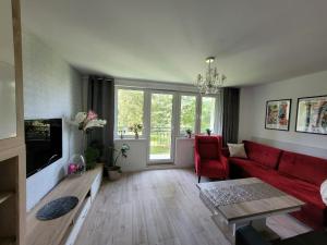 a living room with a red couch and a red chair at Apartament MILANO Chojnice in Chojnice