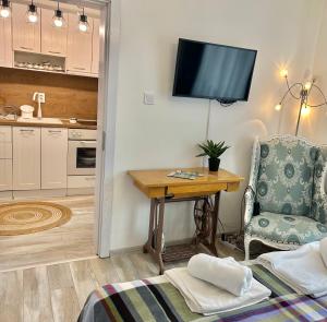 a living room with a table and a tv on the wall at Bulgarane House in Govedartsi
