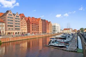 a group of boats docked in a river with buildings at GRANO APARTMENTS Gdańsk Granaria in Gdańsk
