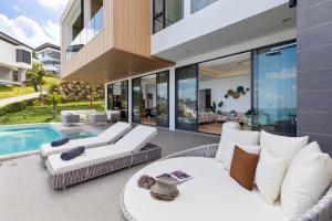an outdoor living room with a swimming pool and a house at Villa Sea Esta Luxury Residence at Chaweng Noi in Koh Samui 