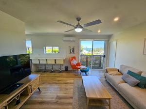 a living room with a couch and a flat screen tv at Summer Villa in Kiama