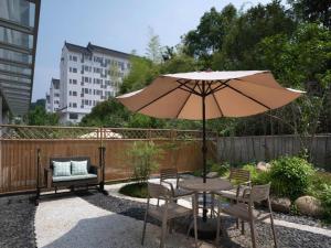 a patio with a table and chairs and an umbrella at Wudangshan Jianguo Hotel in Liuliping