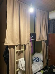 1 dormitorio con litera y cortina en Wake N Flow, Hiriketiya, en Hiriketiya