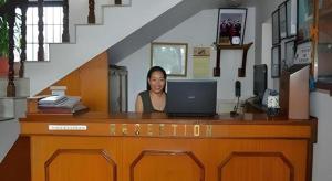 eine Frau, die an einem Schreibtisch mit einem Laptop sitzt in der Unterkunft Hotel Norbu Sangpo in Kathmandu