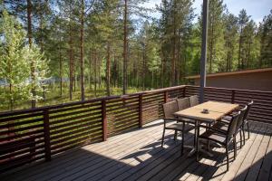 a wooden deck with a table and chairs on it at Kuoreksenniemi Villas & Lakehouse in Puumala