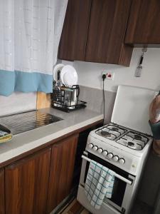 uma cozinha com fogão e micro-ondas em Hami Ventures em Kisumu mais 2 fotografias