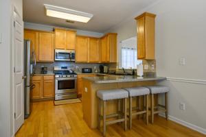 una cucina con armadi in legno e un'isola con sgabelli da bar di 4632 Liberty Square Dr Acworth ad Acworth