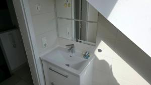a white bathroom with a sink and a mirror at Privatzimmer Freimann in Munich