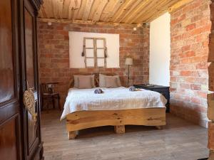 a bedroom with a bed in a brick wall at Halháza vendégház in Sirok