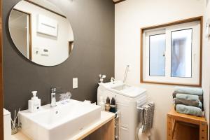 une salle de bain avec un lavabo et un miroir dans l'établissement 鈴鹿サーキット15分最大9名和室亀山茶4月open, à Kameyama