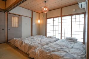 a large bed in a room with large windows at Suzuka Circuit 15min Family House鈴鹿サーキット15分子連れ大歓迎段差無し漫画おもちゃの一棟貸切宿 in Kameyama +114 photos