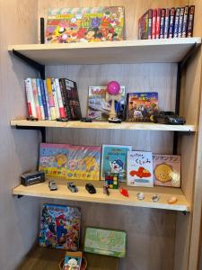 a book shelf filled with books and toys at Suzuka Circuit 15min Family House鈴鹿サーキット15分子連れ大歓迎段差無し漫画おもちゃの一棟貸切宿 in Kameyama