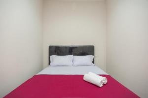 a bed with a red and white blanket on it at Hanna Residence near RSPI Puri Indah Mitra RedDoorz in Meruya-hilir