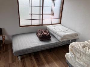 Ένα ή περισσότερα κρεβάτια σε δωμάτιο στο MOTORYOKAN Guesthouse & Cafe