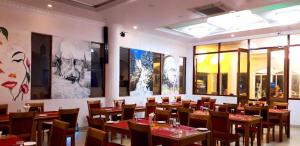 a dining room with wooden tables and chairs at Tilko Jaffna City Hotel in Jaffna