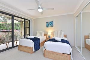 two beds in a room with a balcony at Cleopatra's Oasis at Lagoon Estate in Nelson Bay +22 photos