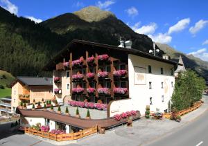 een groot gebouw met bloemen in de ramen bij Hotel Bergland Superior in Sankt Leonhard im Pitztal