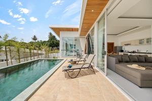 a living room with a couch and a swimming pool at Villa Namo Chaweng 2 Bed Garden Pool in Koh Samui