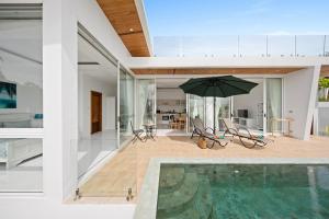 a house with a swimming pool and an umbrella at Villa Namo Chaweng 2 Bed Garden Pool in Koh Samui