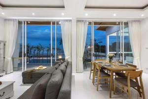 a living room with a long couch and a dining table at Villa Namo Chaweng 2 Bed Garden Pool in Koh Samui