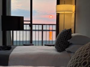 a bedroom with a bed with a view of the ocean at Alim STAY IZU アリムステイ 伊豆 in Toi