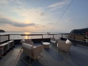 a balcony with chairs and a view of the ocean at Alim STAY IZU アリムステイ 伊豆 in Toi
