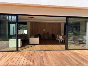 Una casa de cristal con sala de estar y terraza. en Beautiful south-facing architect's house!, en Quimiac