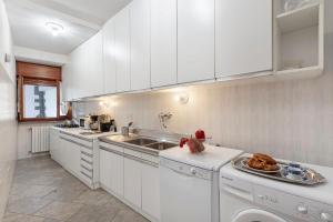 a kitchen with white cabinets and a sink at Casa Malpensata - Happy Rentals in Porto Valtravaglia