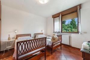 a bedroom with two beds and a table and a window at Casa Malpensata - Happy Rentals in Porto Valtravaglia