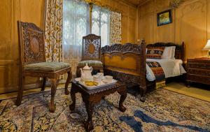 - une chambre avec un lit et une table avec un plateau/bouilloire dans l'établissement Dastan Heritage Houseboats, à Srinagar