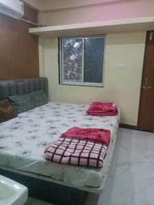 a bed sitting in a room with a window at Hotel siddhi vinayak omkareshwar in Godarpura