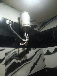 a bucket on the wall of a bathroom at Hotel siddhi vinayak omkareshwar in Godarpura