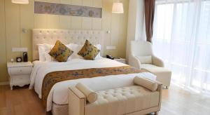 a bedroom with a large white bed and a chair at Wyndham Garden Hotel in Lingshui +90 photos