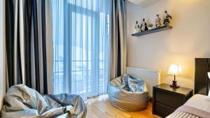 a living room with a large window and a chair at GVC New Gudauri Block-1 in Gudauri