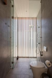 Un baño con inodoro y ducha de cristal. en Brand new 2-bedroom ocean view villa, en Uluwatu