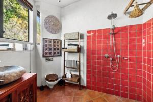 ein Bad mit einer rot gefliesten Dusche und einem WC in der Unterkunft Bali Bliss Villa - Golden Bay in Takaka + 27 Fotos