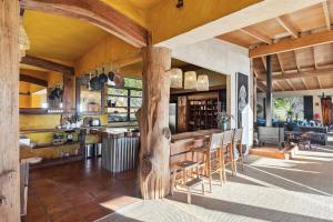 eine Küche mit einem großen Holztisch und Stühlen in der Unterkunft Bali Bliss Villa - Golden Bay in Takaka