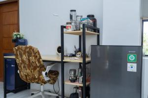 SengkolにあるRumah Nusantaraの冷蔵庫の横に椅子とデスク +4枚の写真