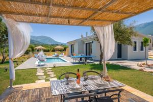 an external view of a villa with a table and chairs at Villa Drogarati Cottage by Villa Plus in Chaliotata