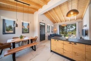 a kitchen and living room with a wooden ceiling at Villa Drogarati Cottage by Villa Plus in Chaliotata